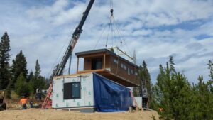 modular pieces of luxury prefabricated homes being set by crane